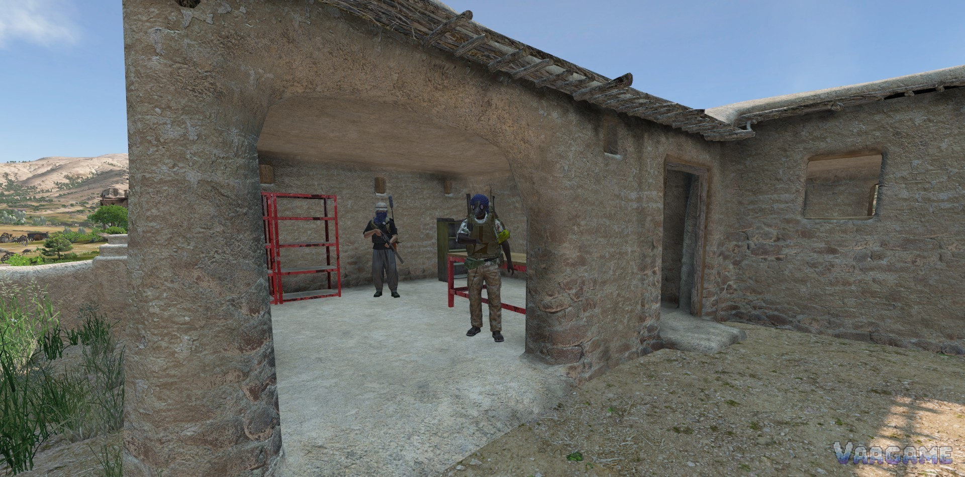 Two survivors in desert clothing inside a mud brick building