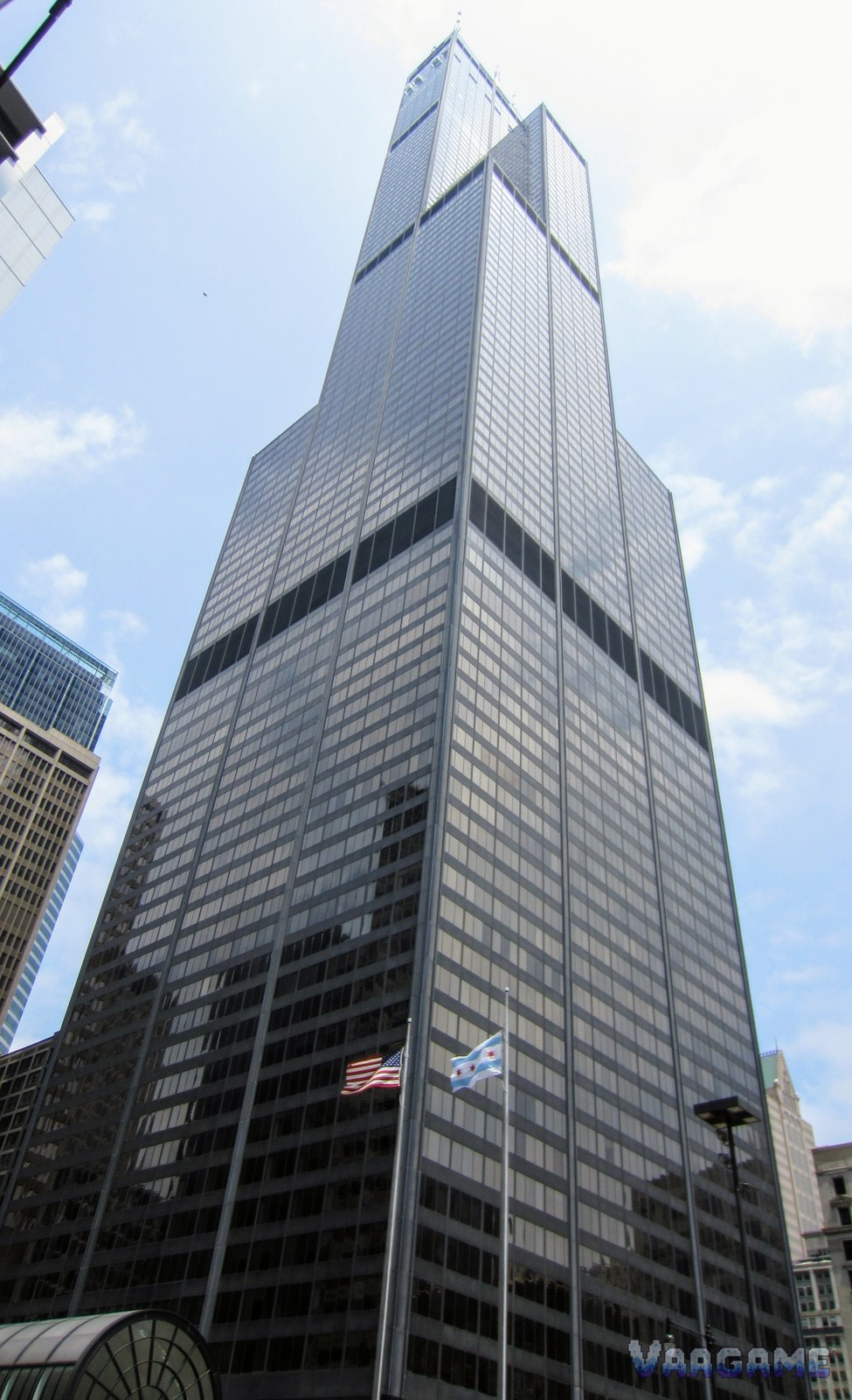 Willis Tower seen from street level looking up against blue sky in Chicago