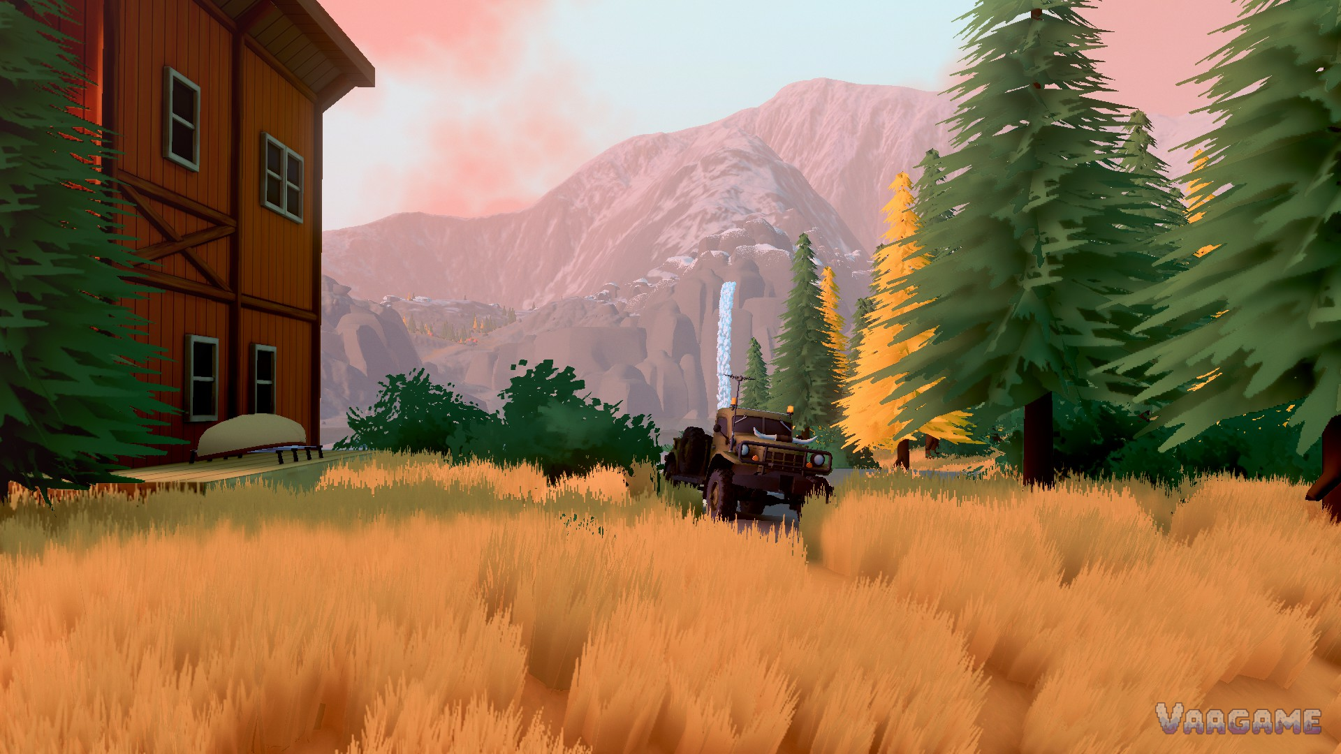 An expedition truck in tall golden grass beside a cabin, a waterfall and snowy peaks behind