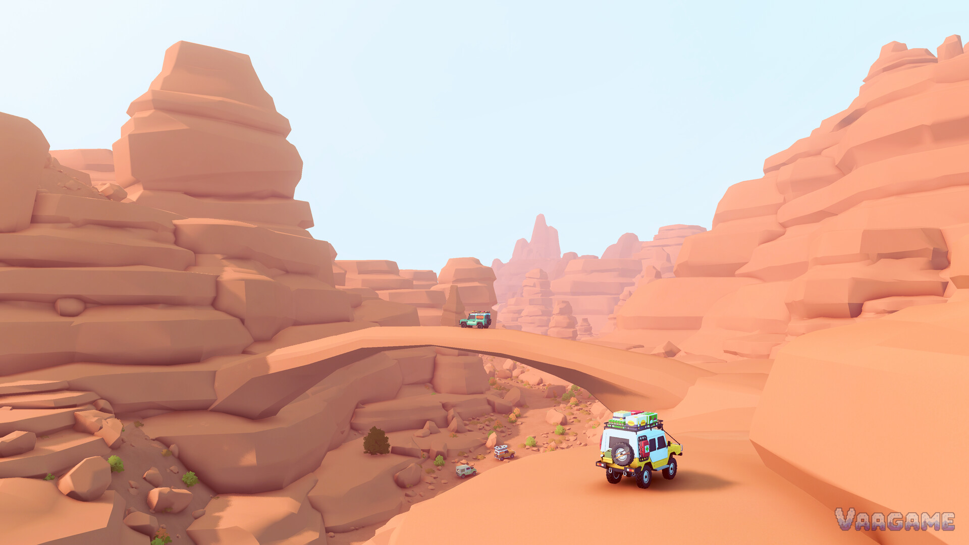 A desert canyon with a natural rock arch and a small convoy crossing the sand