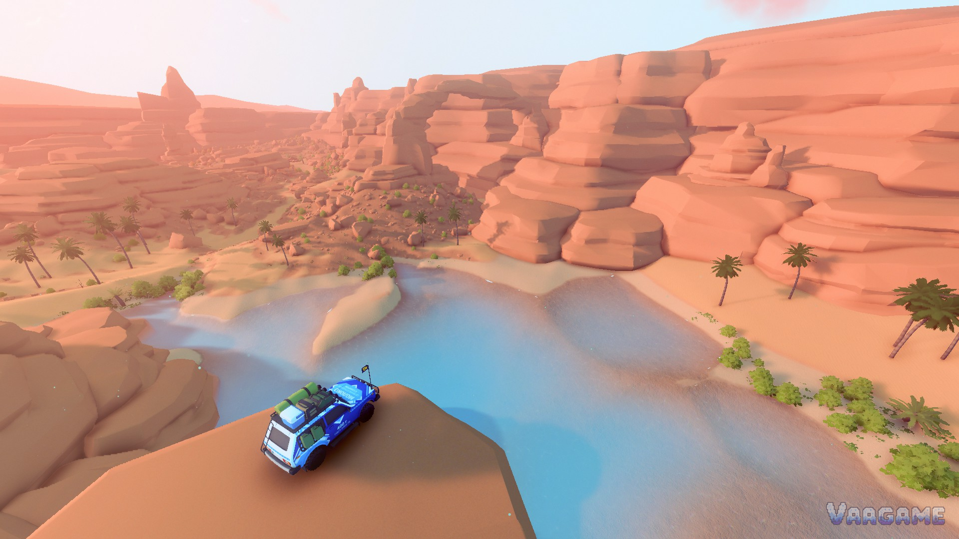 A blue wagon on a mesa rim above a desert river oasis with palms