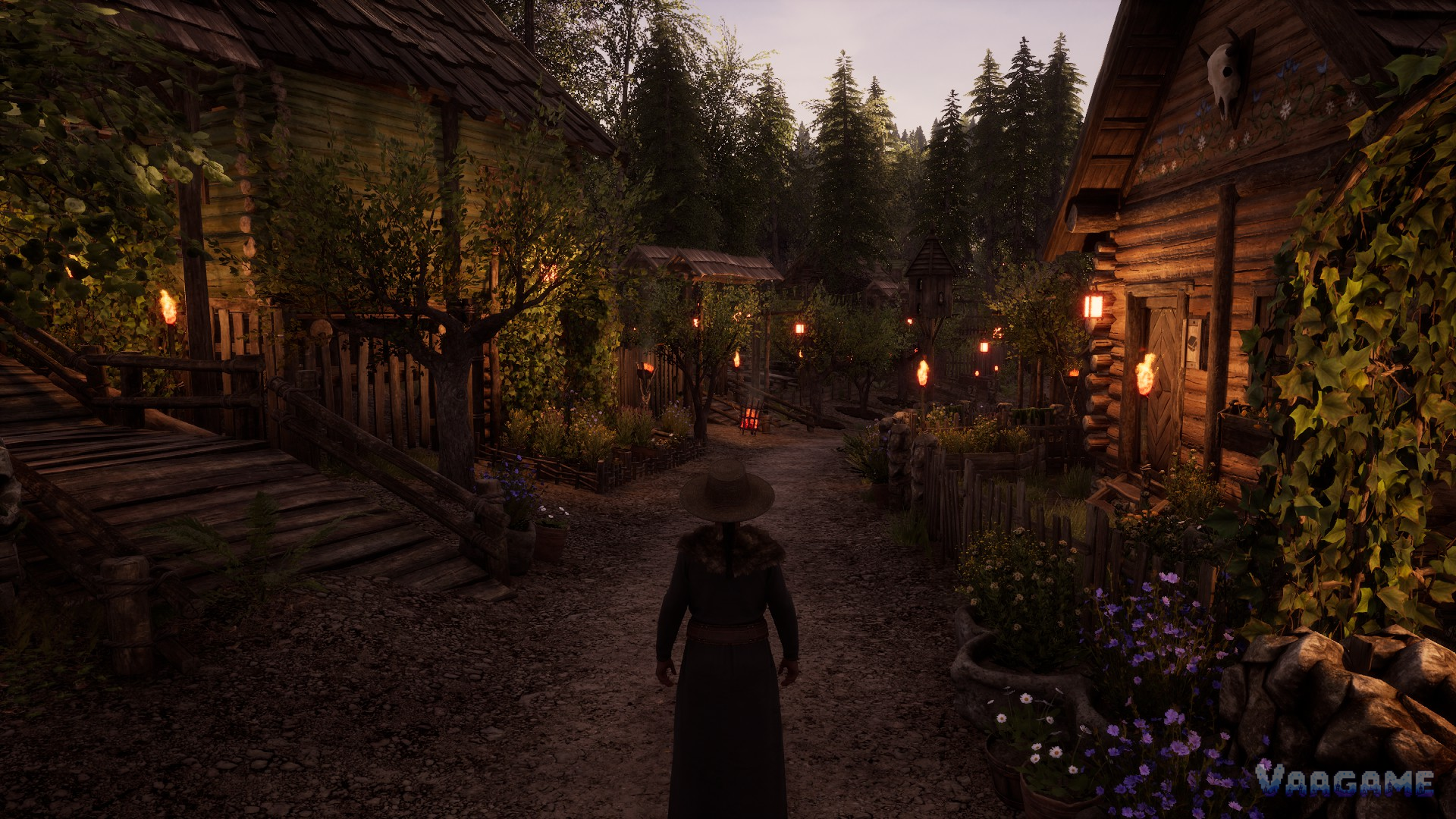 Villager walking a torch lit village street at dusk