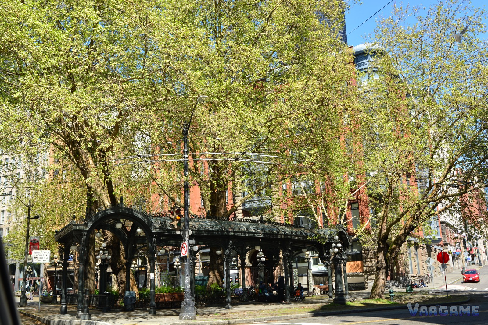 Pioneer Square iron pergola with red brick buildings and trees in daylight Seattle