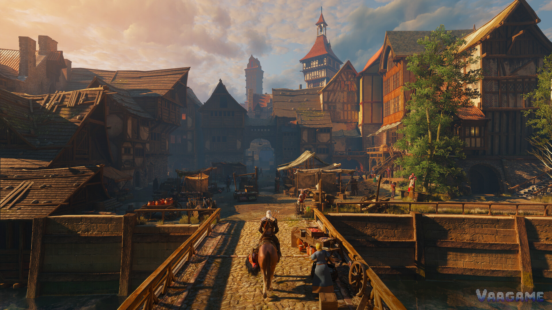 Geralt riding over a bridge into a Novigrad market square lined with stalls at golden hour