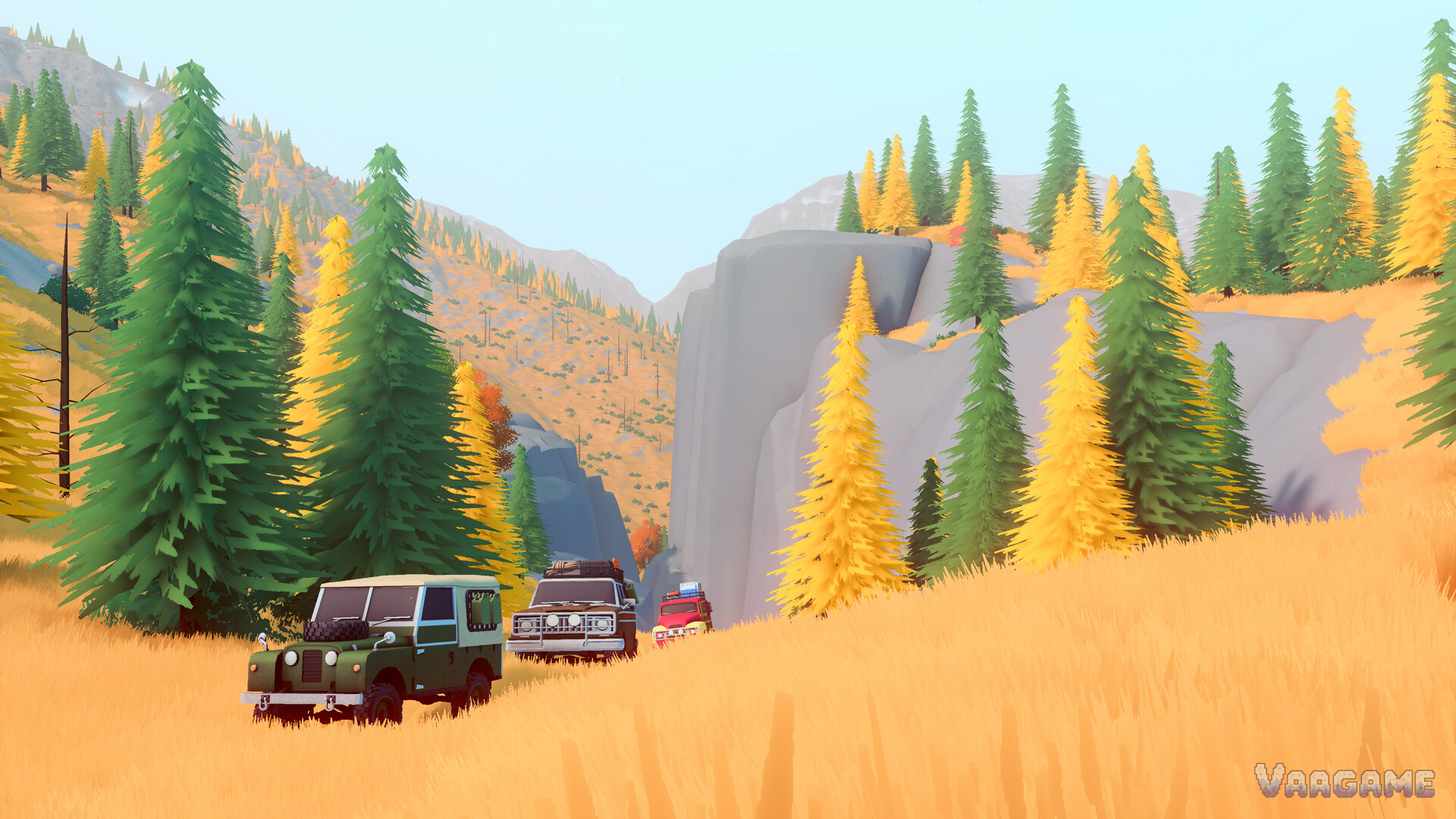 A three-vehicle convoy crossing a golden autumn valley beneath cliffs in Canada